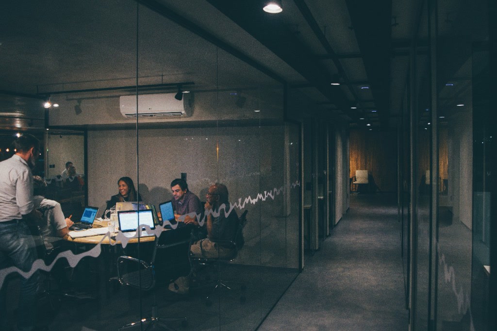 Leadership team collaborating in a glass meeting room